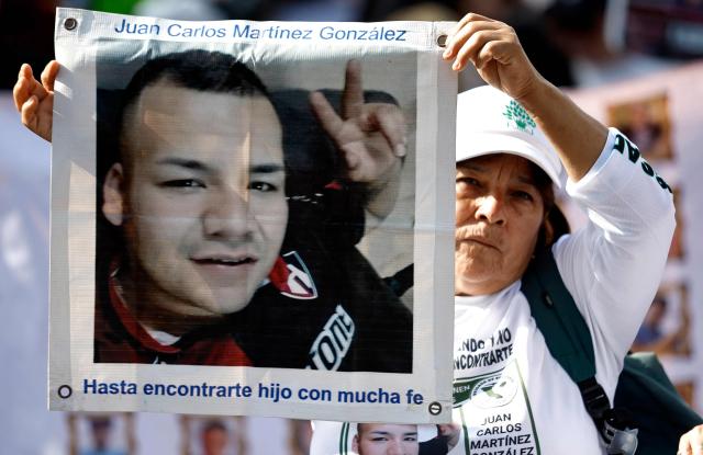 A woman holds a picture of a missing man during a demonstration to mark the International Day of the Victims of Enforced Disappearances in Guadalajara, Jalisco state, Mexico on August 30, 2026. (Photo by ULISES RUIZ / AFP)