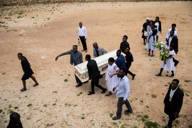 A coffin is carried to be buried during a collective funeral for more than twenty people killed by armed gangs last week in Kenscoff, a neighborhood near Port-au-Prince, on August 30, 2026. Gang members attacked displaced people huddling inside a church near Haiti's capital, killing around 40, some of them execution-style, the mayor told AFP on August 24. (Photo by Clarens SIFFROY / AFP)