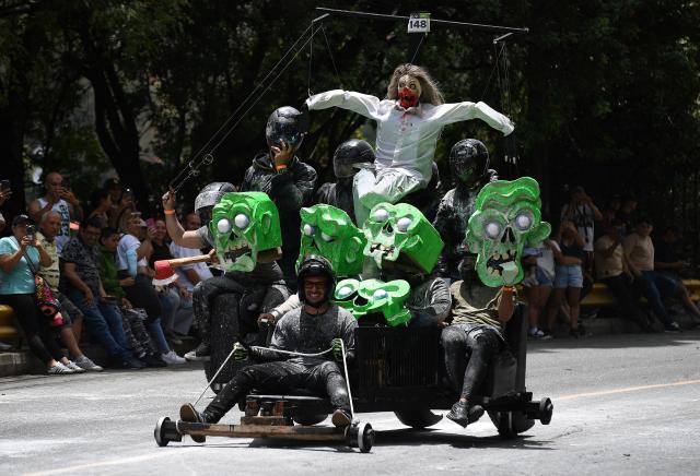 Revelers compete in a downhill makeshift car fun race during the "Festival de Descenso y Adrenalina" in Medellin, Colombia on August 30, 2026. (Photo by JAIME SALDARRIAGA / AFP)