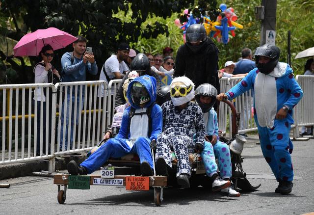 Revelers compete in a downhill makeshift car fun race during the "Festival de Descenso y Adrenalina" in Medellin, Colombia on August 30, 2026. (Photo by JAIME SALDARRIAGA / AFP)