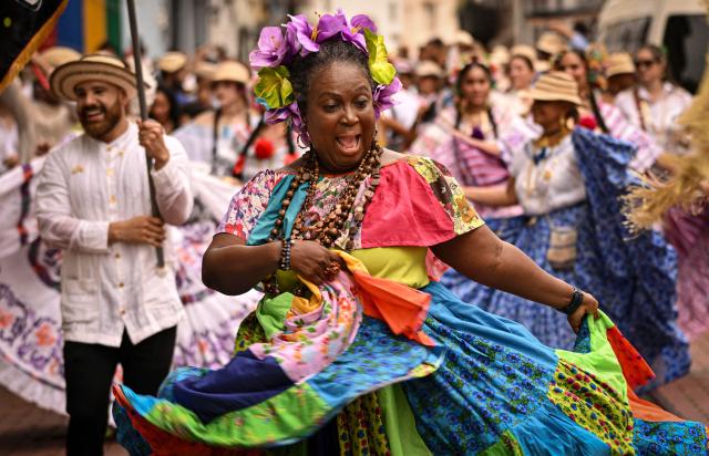 A woman dressed in a traditional custome performs a traditional dance during the 'Casco Peatonal' celebrations in the Casco Antiguo historic district of Panama City on August 30, 2026. The performance is part of a series of cultural events aimed at promoting Panama's traditions and cultural diversity. (Photo by MARTIN BERNETTI / AFP)