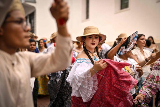 A woman dressed in a traditional custome dances during the 'Casco Peatonal' celebrations in the Casco Antiguo historic district of Panama City on August 30, 2026. The performance is part of a series of cultural events aimed at promoting Panama's traditions and cultural diversity. (Photo by MARTIN BERNETTI / AFP)