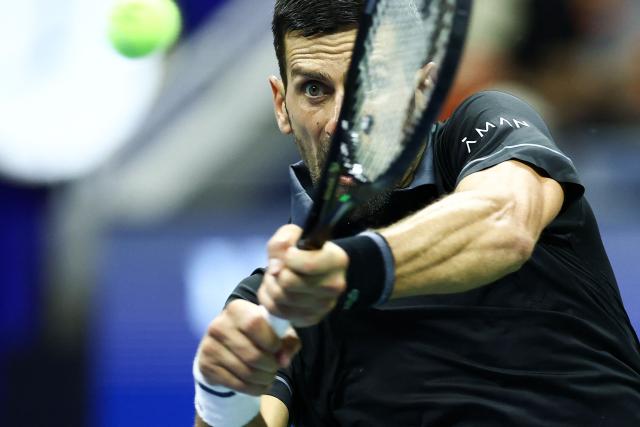 Serbia's Novak Djokovic his a backhand against Argentina's Mariano Navone during the men's singles first round tennis match on day one of the US Open tennis tournament at the USTA Billie Jean King National Tennis Center in New York City on August 30, 2026. (Photo by CHARLY TRIBALLEAU / AFP)