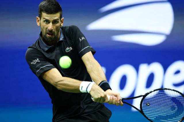 Serbia's Novak Djokovic his a backhand against Argentina's Mariano Navone during the men's singles first round tennis match on day one of the US Open tennis tournament at the USTA Billie Jean King National Tennis Center in New York City on August 30, 2026. (Photo by CHARLY TRIBALLEAU / AFP)