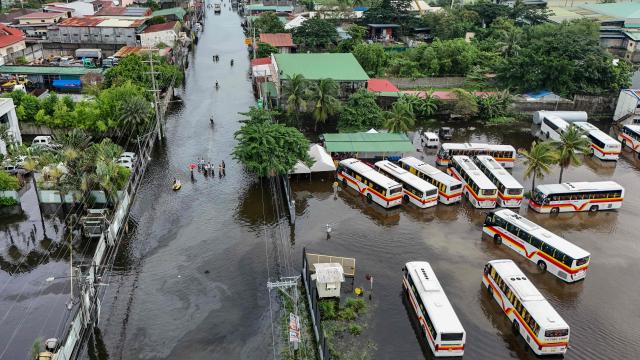 People wade through a flooded street after heavy rains brought by the southwest monsoon in Pampanga on August 31, 2026. (Photo by Jam STA ROSA / AFP)