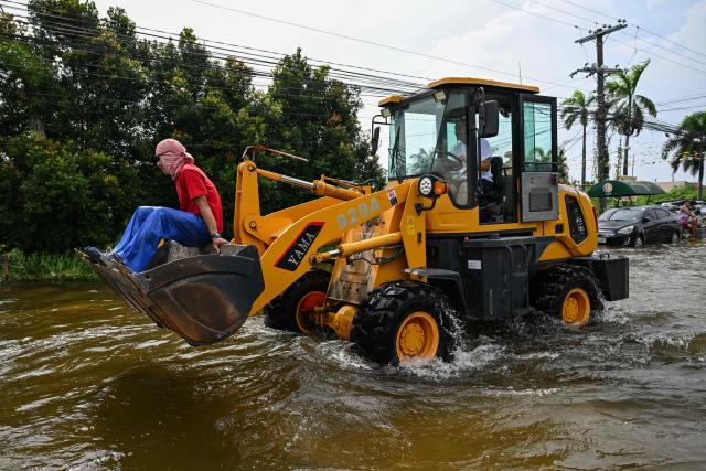 A man rides on a tractor through a flooded street after heavy rains brought by the southwest monsoon in Pampanga on August 31, 2026. (Photo by Jam STA ROSA / AFP)