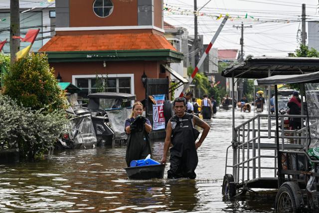 People wade through a flooded street after heavy rains brought by the southwest monsoon in Pampanga on August 31, 2026. (Photo by Jam STA ROSA / AFP)
