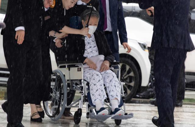 Unification Church leader Han Hak-ja (C in wheelchair) arrives for the sentencing hearing on allegations of bribery and political funding, at the Seoul Central District Court in Seoul on August 31, 2026. (Photo by JEON HEON-KYUN / POOL / AFP)