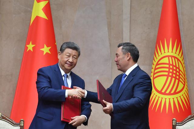Kyrgyzstan's President Sadyr Japarov and China's President Xi Jinping exchange documents during a signing ceremony following their talks in Bishkek on August 31, 2026. (Photo by Vyacheslav OSELEDKO / AFP)