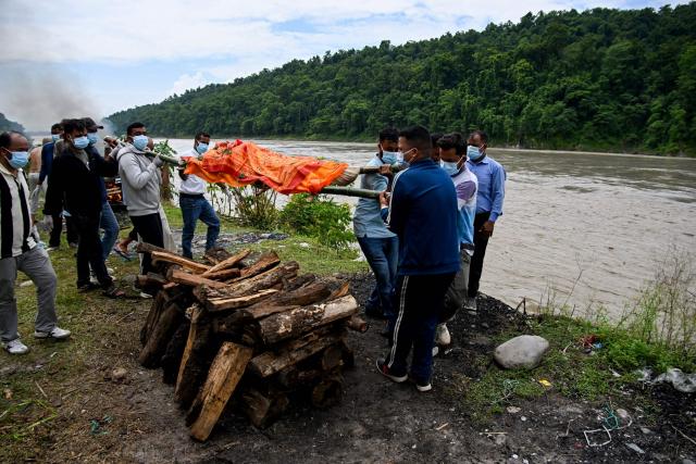Mourners cremate the body of deceased victim Ayush Khadka, after flash floods in Nepal's Chitwan district on August 31, 2026. Nepal was burying on August 31 some of the hundreds of bodies retrieved after a deadly, tsunami-like flood crashed through the Himalayan region, sweeping away villages and leaving thousands still missing. Distraught families have packed rescue stations and hospitals in search of their missing relatives, while others have faced the grim task of identifying bodies at overflowing morgues. (Photo by Prakash MATHEMA / AFP)