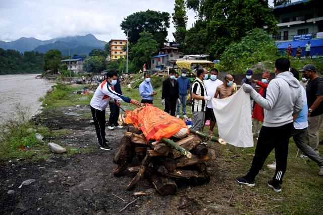 Mourners cremate the body of deceased victim Ayush Khadka, after flash floods in Nepal's Chitwan district on August 31, 2026. Nepal was burying on August 31 some of the hundreds of bodies retrieved after a deadly, tsunami-like flood crashed through the Himalayan region, sweeping away villages and leaving thousands still missing. Distraught families have packed rescue stations and hospitals in search of their missing relatives, while others have faced the grim task of identifying bodies at overflowing morgues. (Photo by Prakash MATHEMA / AFP)