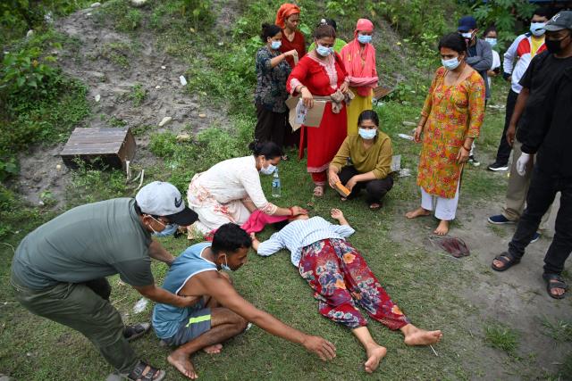 Relatives comfort Monac Khadka (4L) and Krishna Khadka (2L) during their son Ayush Khadka's cremation in the aftermath of flash floods, in Nepal's Chitwan district on August 31, 2026. Nepal was burying on August 31 some of the hundreds of bodies retrieved after a deadly, tsunami-like flood crashed through the Himalayan region, sweeping away villages and leaving thousands still missing. Distraught families have packed rescue stations and hospitals in search of their missing relatives, while others have faced the grim task of identifying bodies at overflowing morgues. (Photo by Prakash MATHEMA / AFP)