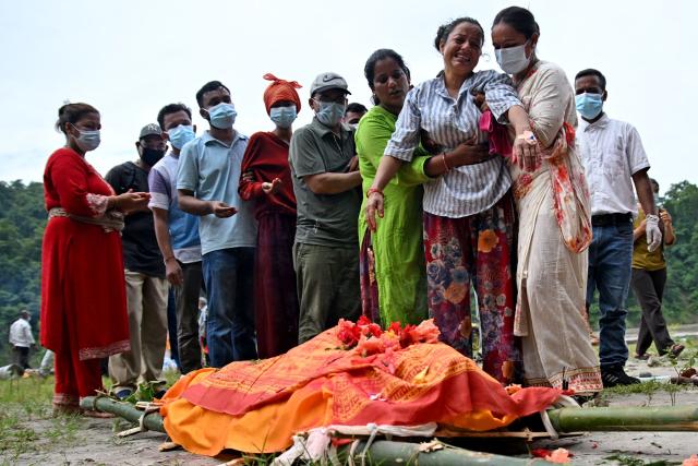 Ayush Khadka's mother Monac Khadka (4R) mourns during her son's cremation in the aftermath of flash floods, in Nepal's Chitwan district on August 31, 2026. Nepal was burying on August 31 some of the hundreds of bodies retrieved after a deadly, tsunami-like flood crashed through the Himalayan region, sweeping away villages and leaving thousands still missing. Distraught families have packed rescue stations and hospitals in search of their missing relatives, while others have faced the grim task of identifying bodies at overflowing morgues. (Photo by Prakash MATHEMA / AFP)