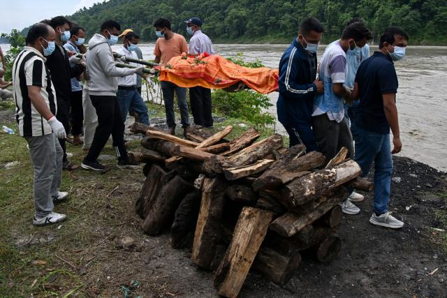 Mourners cremate the body of deceased victim Ayush Khadka, after flash floods in Nepal's Chitwan district on August 31, 2026. Nepal was burying on August 31 some of the hundreds of bodies retrieved after a deadly, tsunami-like flood crashed through the Himalayan region, sweeping away villages and leaving thousands still missing. Distraught families have packed rescue stations and hospitals in search of their missing relatives, while others have faced the grim task of identifying bodies at overflowing morgues. (Photo by Prakash MATHEMA / AFP)