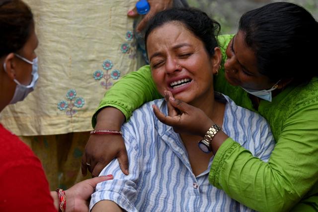 Ayush Khadka's mother Monac Khadka (C) mourns during her son's cremation in the aftermath of flash floods, in Nepal's Chitwan district on August 31, 2026. Nepal was burying on August 31 some of the hundreds of bodies retrieved after a deadly, tsunami-like flood crashed through the Himalayan region, sweeping away villages and leaving thousands still missing. Distraught families have packed rescue stations and hospitals in search of their missing relatives, while others have faced the grim task of identifying bodies at overflowing morgues. (Photo by PRAKASH MATHEMA / AFP)