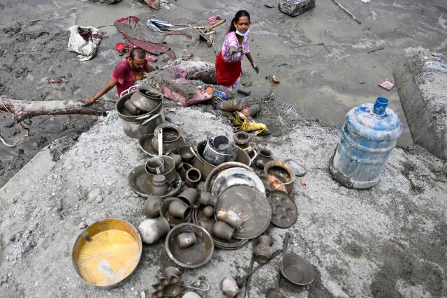 People salvage belongings following flash floods at Devighat in Nepal's Nuwakot district on August 31, 2026. Nepal was burying on August 31 some of the hundreds of bodies retrieved after a deadly, tsunami-like flood crashed through the Himalayan region, sweeping away villages and leaving thousands still missing. Distraught families have packed rescue stations and hospitals in search of their missing relatives, while others have faced the grim task of identifying bodies at overflowing morgues. (Photo by Arun SANKAR / AFP)
