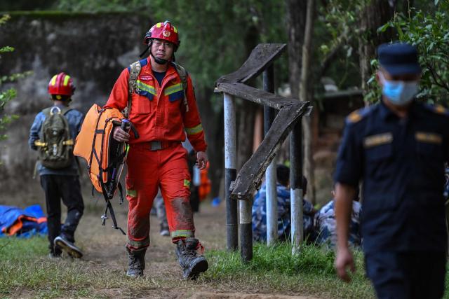China Fire and Rescue personnel arrive at Trishuli camp after inspecting the tunnel site in Rasuwa, in the aftermath of flash floods in Nepal's Nuwakot district on August 31, 2026. Rescuers struggled on August 31 through mud and debris for a sixth day, as the number of missing people soared to nearly 5,000 since tsunami-like glacial floods roared down from the China-Nepal border, creating an "unimaginable" disaster. (Photo by Arun SANKAR / AFP)