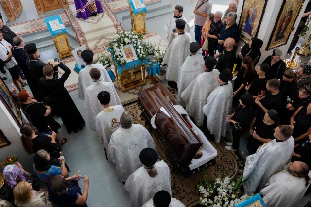 Clergymen stand around the coffin of Taras Didych, head of the Dmytrivka community, who was killed in a Russian attack that killed 37 people on August 29, during his funeral in Dmytrivka, Kyiv region, on August 31, 2026, amid Russia’s invasion of Ukraine. (Photo by Tetiana DZHAFAROVA / AFP)