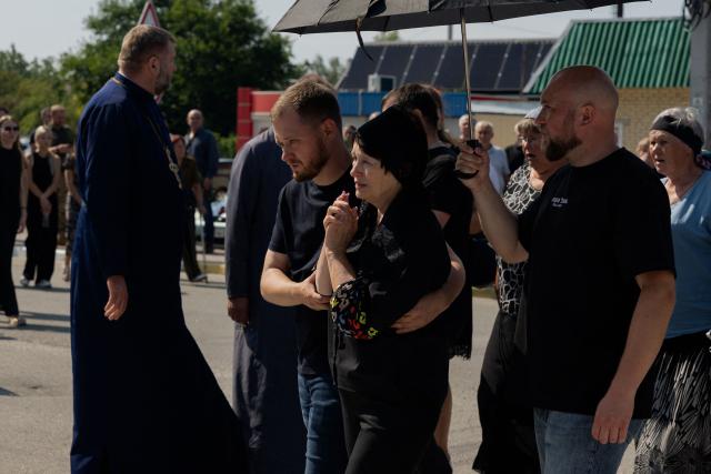Relatives and friends mourn during the funeral of Taras Didych, head of the Dmytrivka community, who was killed in a Russian attack that killed 37 people on August 29, in Dmytrivka, Kyiv region, on August 31, 2026, amid Russia’s invasion of Ukraine. (Photo by Tetiana DZHAFAROVA / AFP)