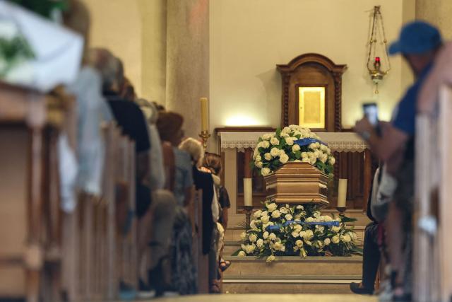 Attendees take their seats as they attend the funeral for the late journalist and radio host Philippe Bouvard, in Cannes, south-eastern France on August 31, 2026. Journalist and radio host Philippe Bouvard, a prominent media figure, died on August 24, 2026 at the age of 96, announced the station RTL; he was a pillar of the station and had created the show "Les Grosses Têtes" nearly 50 years ago. (Photo by Valery HACHE / AFP)