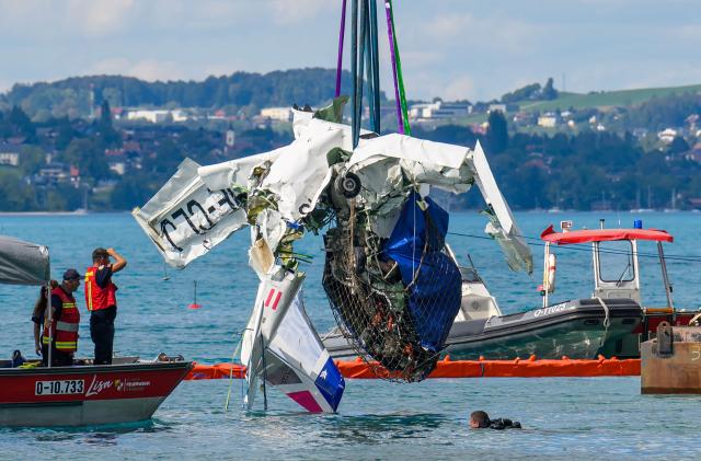 Members of the firebrigade watch as the wreckage of a small aircraft, that crashed on August 26 into Lake Attersee, is retrieved from the lake in the Steinbach area, Upper Austria, on August 31, 2026. The propeller plane that crashed into Lake Attersee near Steinbach last Wednesday, August 26 resulting in the deaths of its two passengers, was recovered on August 31 from a depth of 160 meters. (Photo by Werner KERSCHBAUMMAYR / various sources / AFP) / Austria OUT