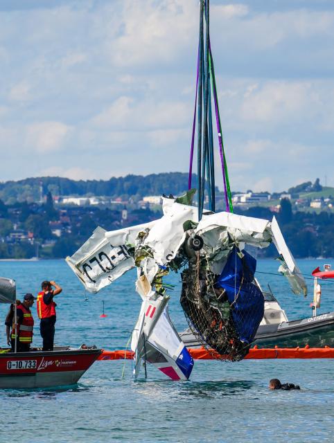 Members of the firebrigade watch as the wreckage of a small aircraft, that crashed on August 26 into Lake Attersee, is retrieved from the lake in the Steinbach area, Upper Austria, on August 31, 2026. The propeller plane that crashed into Lake Attersee near Steinbach last Wednesday, August 26 resulting in the deaths of its two passengers, was recovered on August 31 from a depth of 160 meters. (Photo by Werner KERSCHBAUMMAYR / various sources / AFP) / Austria OUT