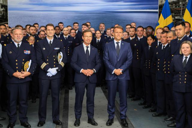 French President Emmanuel Macron (C-R) and Swedish Prime Minister Ulf Kristersson (C-L) pose for a group picture with crew members aboard the French frigate Amiral Ronarc’h in Stockholm, Sweden, on August 31, 2026, following the signing of a 4.3-billion-euro contract for Sweden’s acquisition of four French-built defence and intervention frigates (FDI). (Photo by Ludovic MARIN / AFP)