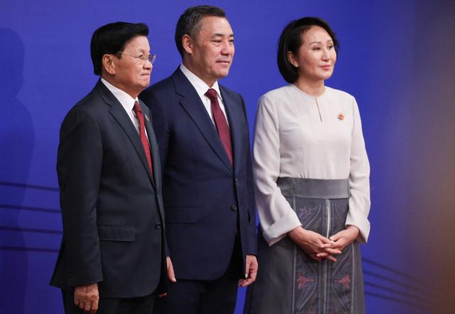 In this pool photograph distributed by the Russian state agency Sputnik, Laotian President Thongloun Sisoulith poses with Kyrgyzstan's President Sadyr Japarov and first lady Aigul prior to the opening ceremony of the 6th World Nomad Games at the Bishkek Arena in Bishkek on August 31, 2026. (Photo by Vyacheslav PROKOFYEV / POOL / AFP)