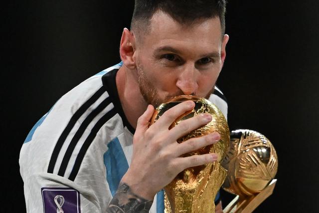 (FILES) Argentina's captain and forward #10 Lionel Messi kisses the FIFA World Cup Trophy during the trophy ceremony after Argentina won the Qatar 2022 World Cup final football match between Argentina and France at Lusail Stadium in Lusail, north of Doha on December 18, 2022. Argentine football star Lionel Messi announced on August 31, 2026, that he is retiring from the Argentina national team, almost a month and a half after losing the 2026 World Cup final to Spain. (Photo by Paul ELLIS / AFP)