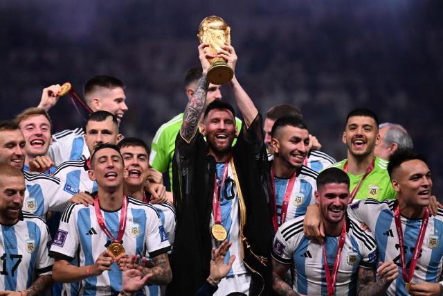 (FILES) Argentina's captain and forward #10 Lionel Messi (C) lifts the FIFA World Cup Trophy on stage as he celebrates with teammates after they won the Qatar 2022 World Cup final football match between Argentina and France at Lusail Stadium in Lusail, north of Doha on December 18, 2022. Argentine football star Lionel Messi announced on August 31, 2026, that he is retiring from the Argentina national team, almost a month and a half after losing the 2026 World Cup final to Spain. (Photo by Kirill KUDRYAVTSEV / AFP)