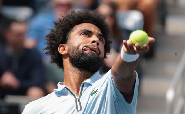 France's Arthur Fils serves to Greece's Stefanos Tsitsipas during the men's singles first round tennis match on day two of the US Open tennis tournament at the USTA Billie Jean King National Tennis Center in New York City on August 31, 2026. (Photo by KENA BETANCUR / AFP)