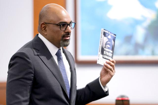 Chief Deputy District Attorney Binu Palal holds a copy of Duane Davis’ book “Compton Street Legends” during closing arguments in the Duane Davis murder trial, related to the 1996 killing of rapper Tupac Shakur, at Clark County District Court at the Regional Justice Center in Las Vegas, Nevada, on August 31, 2026. The trial of the former gang leader accused of orchestrating the murder of rapper Tupac Shakur began on August 10, 30 years after one of America's most high-profile unresolved killings. The proceedings, expected to last a month, will likely not make clear who fired the shots that killed the California hip-hop legend on the night of September 7, 1996, while he was in Las Vegas to see a Mike Tyson boxing match. (Photo by STEVE MARCUS / POOL / AFP)