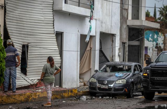 Residents look at the damage caused by a car bomb explosion in front of the municipal police station in Ojocaliente, Zacatecas, Mexico, on August 31, 2026. A car bomb exploded on August 30 night in front of a police station in Mexico, wounding six people, authorities said. The attack took place in the state of Zacatecas, which has key routes for drug trafficking. (Photo by Jess Mireles / AFP)