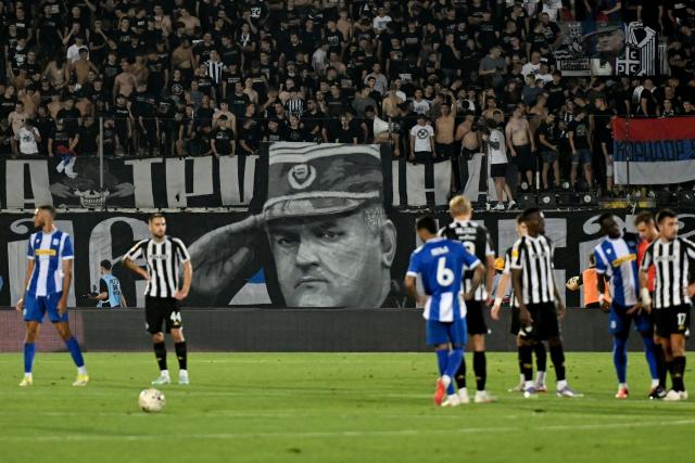 Partizan Belgrade supporters display a banner depicting former Bosnian Serb military chief Ratko Mladic during the Serbian SuperLiga football match between Partizan Belgrade and OFK Beograd in Belgrade on August 31, 2026, days after Mladic died at the age of 84 in a hospital in The Hague. Ratko Mladic, the former Bosnian Serb military chief dubbed the "Butcher of Bosnia" for his role in the 1995 Srebrenica massacre, has died, Serbian state broadcaster RTS reported on August 27, 2026. (Photo by OLIVER BUNIC / AFP)