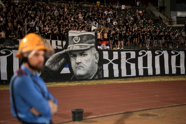 Partizan Belgrade supporters display a banner depicting former Bosnian Serb military chief Ratko Mladic during the Serbian SuperLiga football match between Partizan Belgrade and OFK Beograd in Belgrade on August 31, 2026, days after Mladic died at the age of 84 in a hospital in The Hague. Ratko Mladic, the former Bosnian Serb military chief dubbed the "Butcher of Bosnia" for his role in the 1995 Srebrenica massacre, has died, Serbian state broadcaster RTS reported on August 27, 2026. (Photo by OLIVER BUNIC / AFP)
