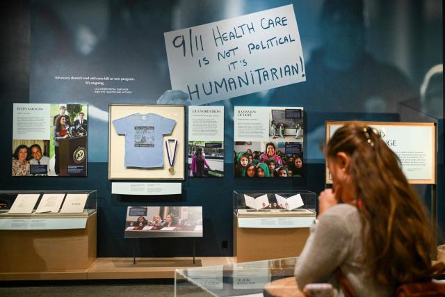 A member of the media views an exhibit at a press preview of the 9/11 Memorial & Museum’s exhibition, “In Their Honor: 25 Years of 9/11 Inspired Service”, exploring the legacy of service inspired by September 11, 2001, in New York, on August 31, 2026. September 11, 2026 will mark the 25th anniversary of the September 11, 2001 attacks. (Photo by ANGELA WEISS / AFP)