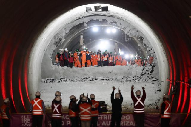 Workers celebrate the tunnel meeting at the construction site for Santiago Metro Line 6 in Santiago on August 31, 2026. (Photo by Javier TORRES / AFP)