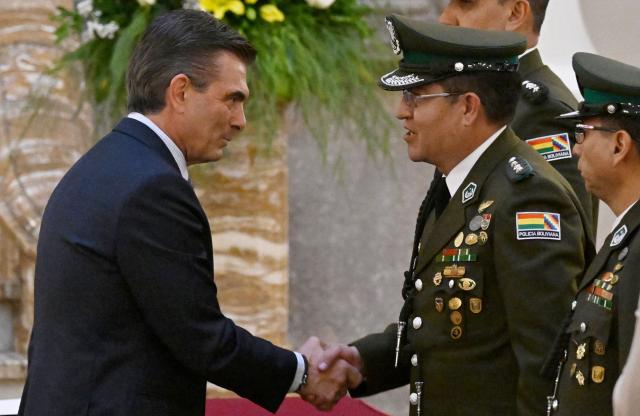 Bolivia's President Rodrigo Paz (L) shakes hands with Colonel Adrian Javier Alvarez after his swearing in ceremony as the new interim Commander-in-chief of the Bolivian Police, following the resignation of Mirko Sokol at the Government Palace in La Paz on August 31, 2026. (Photo by Aizar RALDES / AFP)