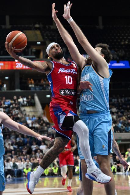 Puerto Rico's Jose Alvarado (L) attempts a lay-up as he is defended by Uruguay's Emiliano Serres during the FIBA Basketball World Cup 2027 Americas qualifiers Group F match between Uruguay and Puerto Rico at the Antel Arena stadium in Montevideo on August 31, 2026. (Photo by Eitan ABRAMOVICH / AFP)