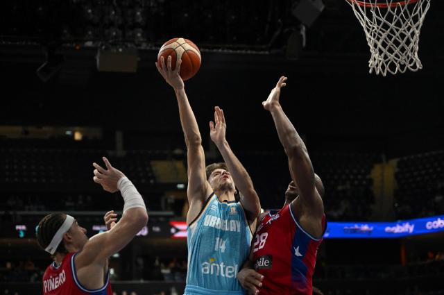 Uruguay's Joaquin Rodriguez (C) attempts a lay-up as he is defended by Puerto Rico's Ismael Romero during the FIBA Basketball World Cup 2027 Americas qualifiers Group F match between Uruguay and Puerto Rico at the Antel Arena stadium in Montevideo on August 31, 2026. (Photo by EITAN ABRAMOVICH / AFP)