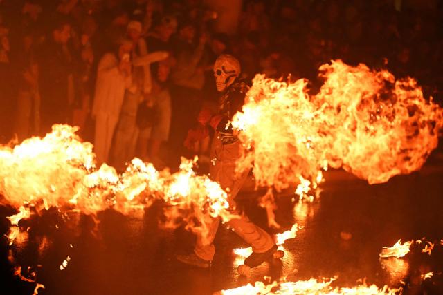 A reveler attends the traditional "Fireball Festival" in Nejapa, El Salvador, on August 31, 2026. The annual festival, dating back to 1922, is held in honour of Saint Jerome and commemorates the 1658 eruption of the San Salvador volcano that destroyed the town of Nejapa. (Photo by Marvin RECINOS / AFP)