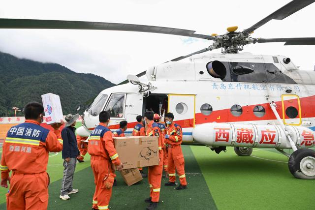 Firefighters from the Tibet Corps of the National Comprehensive Fire and Rescue Team unload emergency supplies from a helicopter at the mudslide-hit Gyirong Port in Gyirong County, in China’s western Tibet region on August 31, 2026. (Photo by CNS / AFP) / China OUT