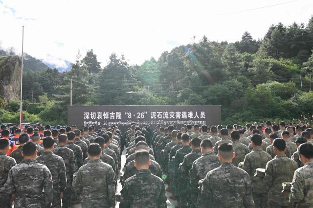 Rescue officers and paramilitary police attend a memorial service for victims of a mudslide at the Gyirong Port police station in Gyirong County, in China’s western Tibet region on September 1, 2026. (Photo by CNS / AFP) / China OUT
