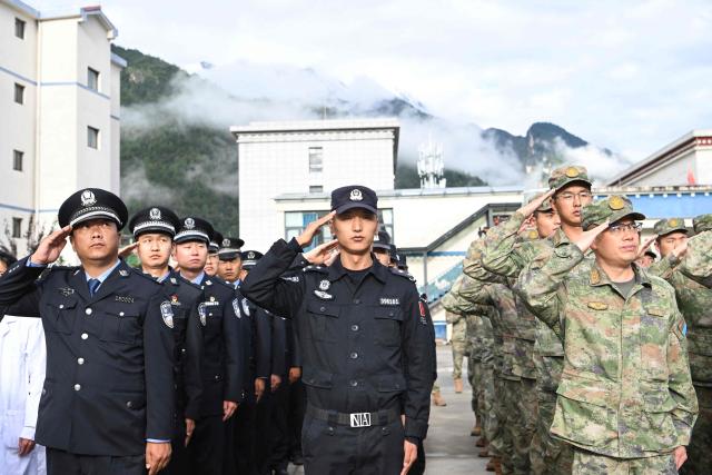 Local officials and paramilitary police attend a memorial service for victims of a mudslide at the Gyirong Port police station in Gyirong County, in China’s western Tibet region on September 1, 2026. (Photo by CNS / AFP) / China OUT