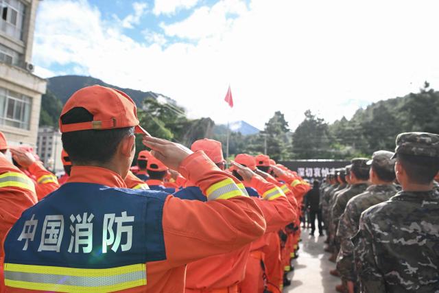 Rescue officers and paramilitary police attend a memorial service for victims of a mudslide at the Gyirong Port police station in Gyirong County, in China’s western Tibet region on September 1, 2026. (Photo by CNS / AFP) / China OUT