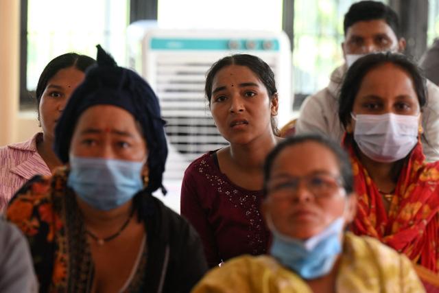Relatives look at a screen to identify deceased victims at a mortuary, after flash floods hit Bharatpur in Nepal's Chitwan district on September 1, 2026. The huge wave of freezing water and debris, sparked by a glacial collapse on the China-Nepal border, killed at least 939 people and left nearly 4,500 missing, with Kathmandu warning reconstruction costs could run into the "billions of dollars". (Photo by Prakash MATHEMA / AFP)