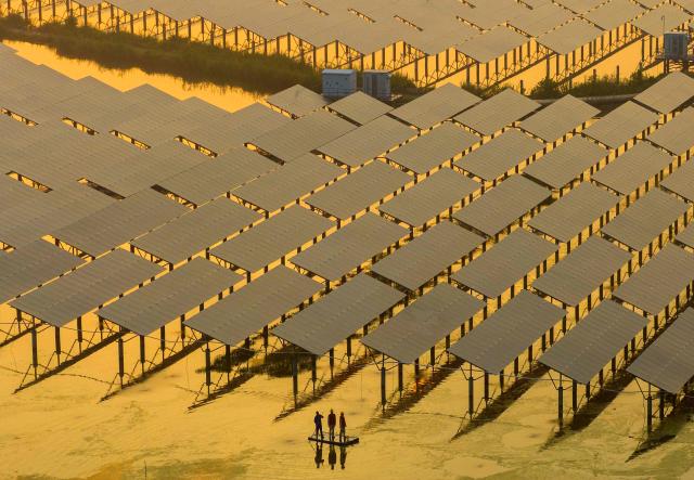 (FILES) Workers inspect solar panels at the fishing-solar complementary photovoltaic power generation base in  Taizhou, in China’s eastern Jiangsu province on July 12, 2023. China's installed solar energy capacity has surpassed that of coal-fired power for the first time, the national energy body said on September 1, 2026, hailing the milestone. (Photo by CN-STR / AFP) / China OUT