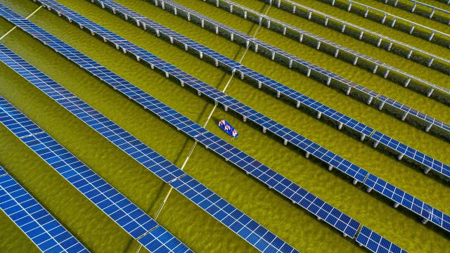 (FILES) This aerial photo taken on July 19, 2021 shows electrical workers in a boat as they check solar panels at a photovoltaic power station built in a fishpond in Haian in China's eastern Jiangsu province. China's installed solar energy capacity has surpassed that of coal-fired power for the first time, the national energy body said on September 1, 2026, hailing the milestone. (Photo by CN-STR / AFP) / China OUT