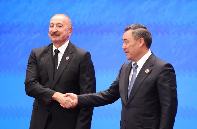 In this pool photograph distributed by the Russian state agency Sputnik, Kyrgyzstan's President Sadyr Japarov welcomes Azerbaijan's President Ilham Aliyev prior to the Shanghai Cooperation Organisation (SCO) summit in Bishkek on September 1, 2026. (Photo by Peter KOVALEV / POOL / AFP)