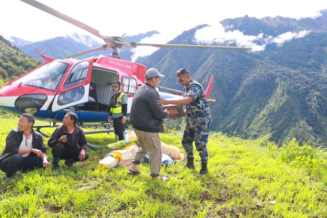 Nepal Armed Police Force personnel unload relief supplies from a helicopter for flood affected people in Nepal's Rasuwa district on September 1, 2026. The huge wave of freezing water and debris, sparked by a glacial collapse on the China-Nepal border, killed at least 939 people and left nearly 4,500 missing, with Kathmandu warning reconstruction costs could run into the "billions of dollars". (Photo by PRABIN RANABHAT / AFP)